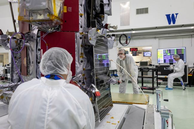 Members of the Parker Solar Probe team examine and align one of the two solar arrays that will power the spacecraft during its seven-year mission to the Sun. The solar arrays are cooled by a gallon of water that circulates through small tubes in the arrays and into large radiators at the top of the spacecraft. 