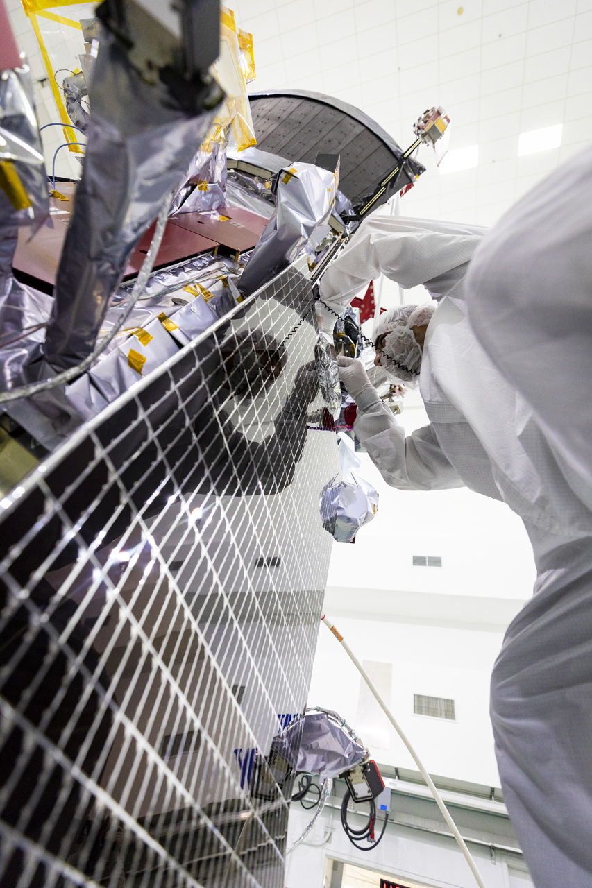 A member of the Parker Solar Probe team examines one of the spacecraft’s two solar arrays that will power the spacecraft during its seven-year mission to the Sun. The solar arrays are cooled by a gallon of water that circulates through small tubes in the arrays and into large radiators, visible at the top of the spacecraft. 
