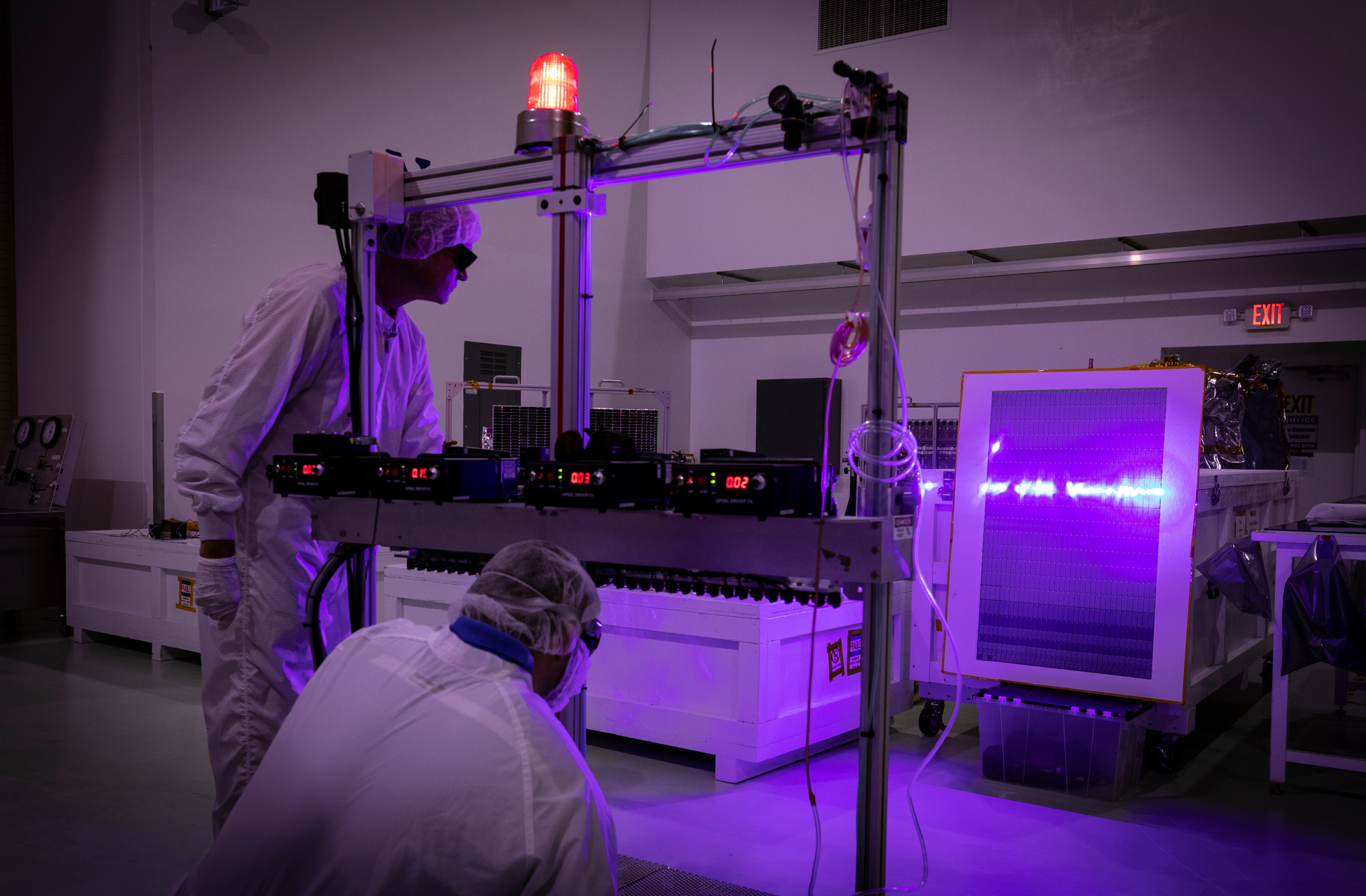Andrew Gerger of the Johns Hopkins Applied Physics Laboratory and Rick Stall of Newforge Technologies check and adjust a purple laser using a replica of a solar array wing on May 3, 2018. Later, when the solar arrays are attached to the spacecraft, the laser will be used to illuminate each string of cells on the array to confirm the string is connected and will provide power to the spacecraft. 