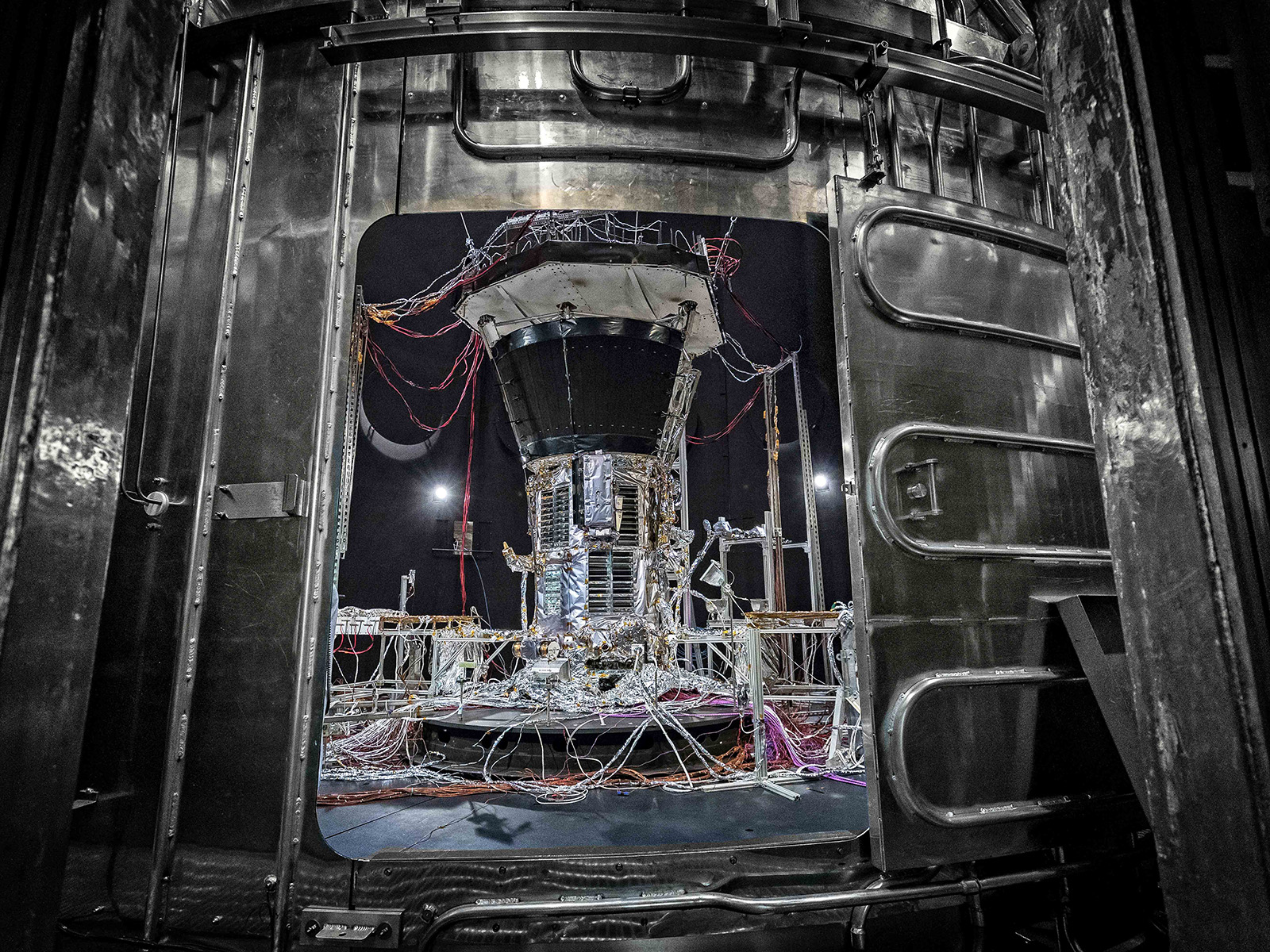 NASA’s Parker Solar Probe, shown inside the thermal vacuum chamber at NASA’s Goddard Space Flight Center just before the main hatch is closed to begin space environment testing. The thermal vacuum chamber duplicates the airless environment of space and simulates the cold and hot temperature cycles the spacecraft will endure during its seven-year exploration of the Sun. 