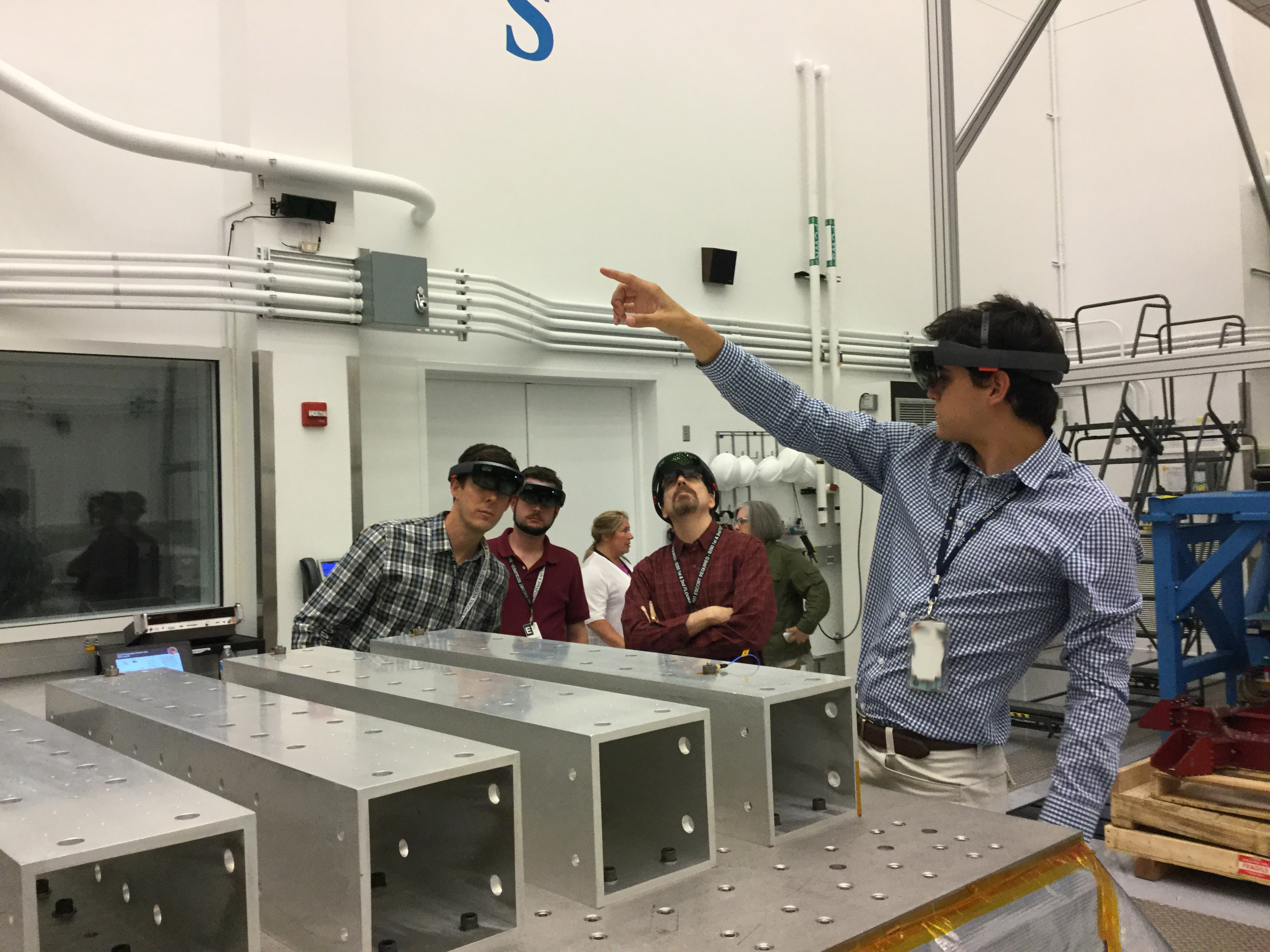 Felipe Ruiz, of Johns Hopkins APL, points to a section of the Parker Solar Probe spacecraft visible only to the group wearing HoloLens augmented reality glasses.