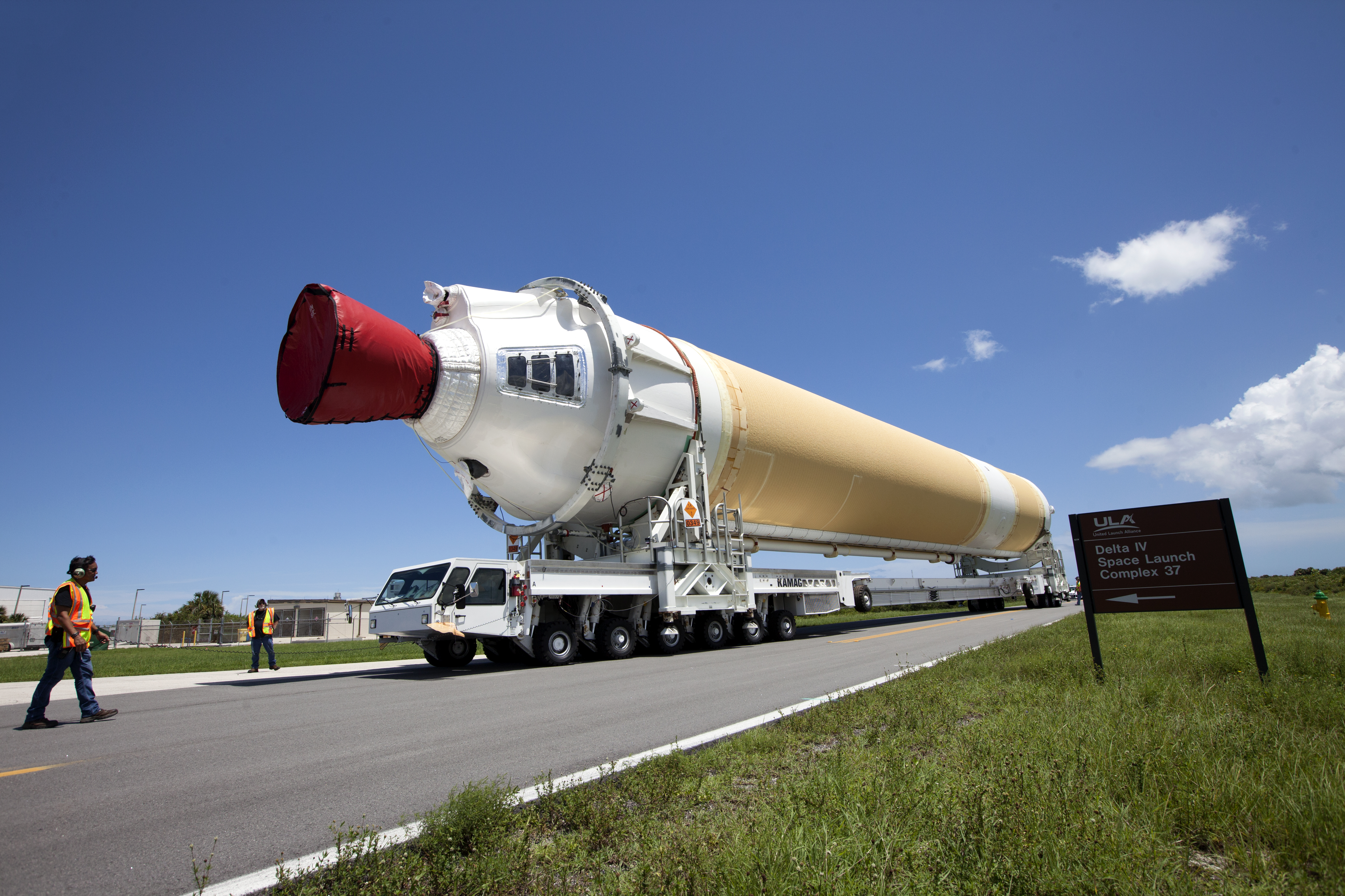 A United Launch Alliance Delta IV Heavy common booster core is transported by truck to Cape Canaveral Air Force Station’s Launch Complex 37 Horizontal Processing Facility after arriving at Port Canaveral. The Delta IV Heavy will launch NASA’s upcoming Parker Solar Probe mission.