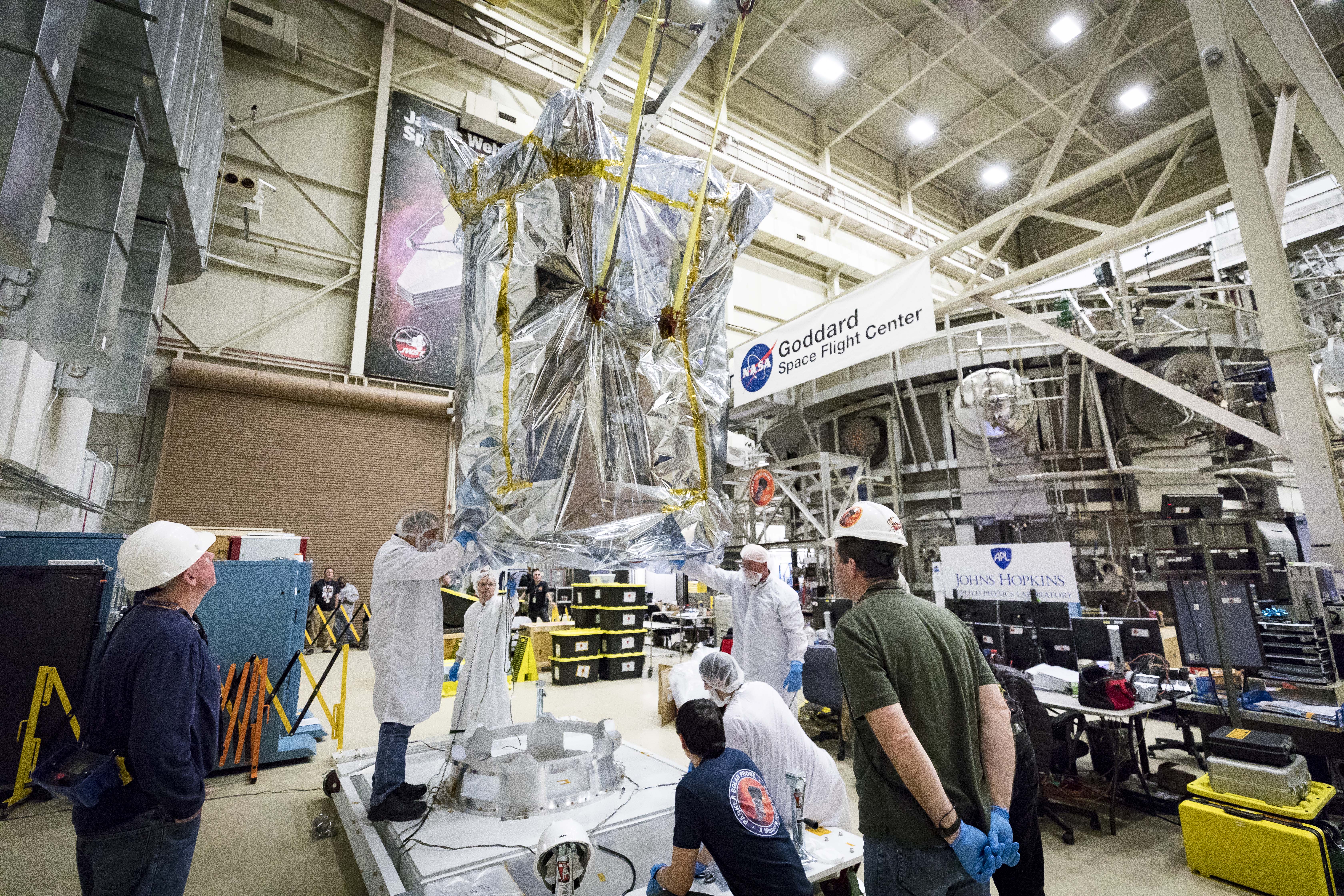 Members of the Parker Solar Probe team from the Johns Hopkins Applied Physics Lab and NASA’s Goddard Space Flight Center carefully lower the spacecraft onto a specially built platform on March 24, 2018. The probe has spent eight weeks undergoing space environment testing, including hot and cold cycling tests that mimic the temperature changes the spacecraft will experience during its seven-year long exploration of the Sun. 